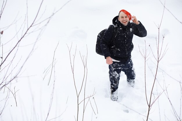 森の中の冬の男。冬はバックパックを持った観光客が森の中を通り抜けます。冬の上昇。