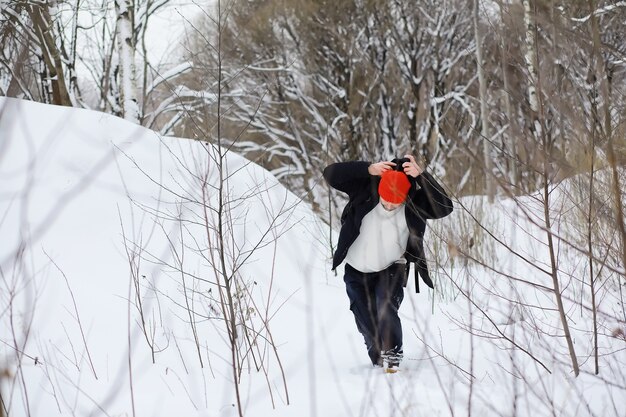 A man in the winter in the forest. A tourist with a backpack goes through the woods in winter. Winter ascent.