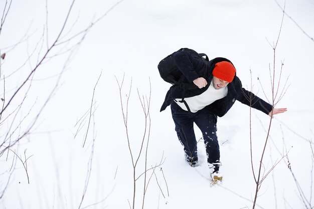 A man in the winter in the forest. A tourist with a backpack goes through the woods in winter. Winter ascent.