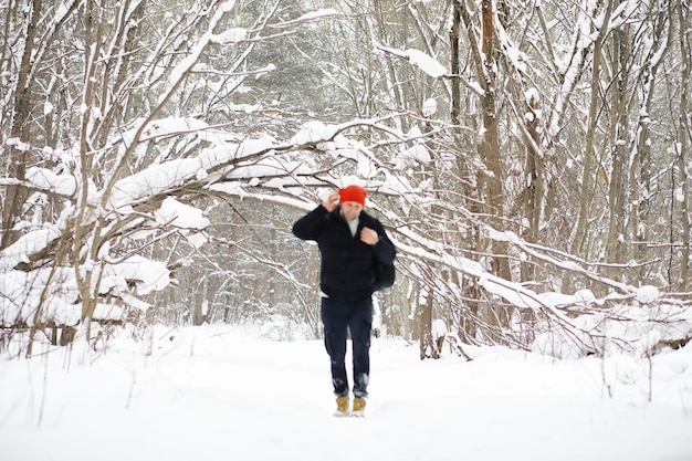 森の中の冬の男。冬はバックパックを持った観光客が森の中を通り抜けます。冬の上昇。