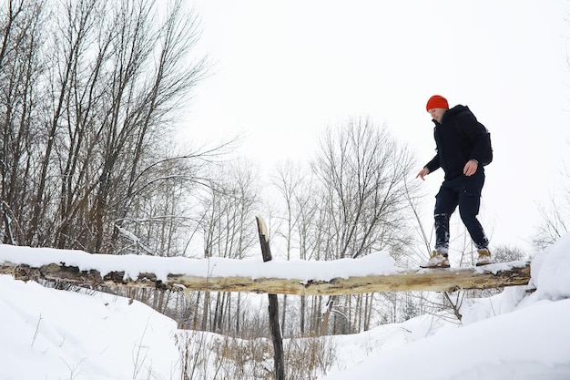 A man in the winter in the forest. A tourist with a backpack goes through the woods in winter. Winter ascent.