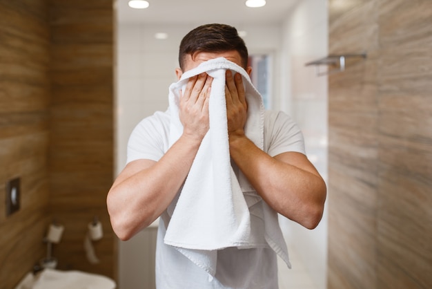 Man wipes his face with a towel