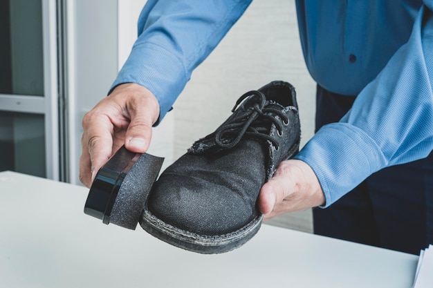 Man wipes shoes with a special soaked sponge cleaning dance\
shoes