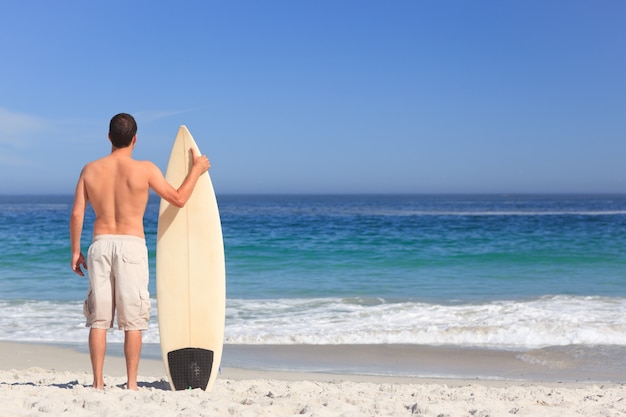 Man wirth his surfboard on the beach