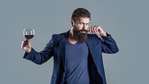 Фото Мужчина с бокалом красного вина в руках дегустатор сомелье с бокалом вина винодельня мужчина-винодел бородатый мужчина бородатый сомелье дегустирует красное вино