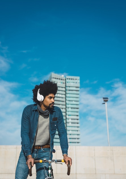 Man with afro hair riding a vintage style bicycle 