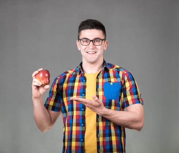 Man with apple isolated on gray wall