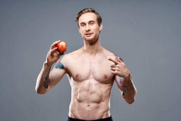 Man with apple and sport healthy food pumped up cake bodybuilder