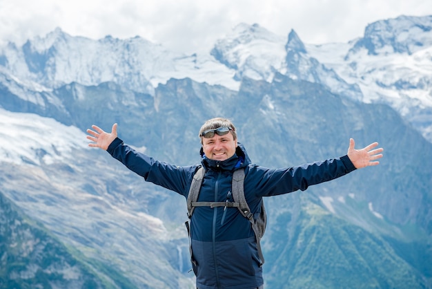 Man with arms up on the top of the mountain  Hiker on the cliff raising hands to the sky