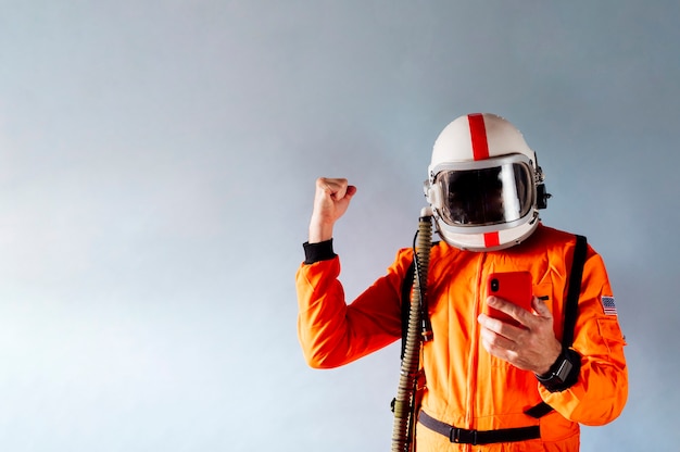 man with astronaut suit and mobile phone