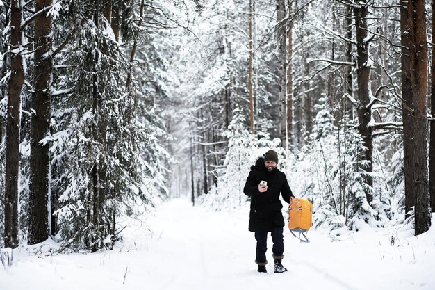 A man with a backpack travels in winter a man in a snowy field\
hiking winter landscape