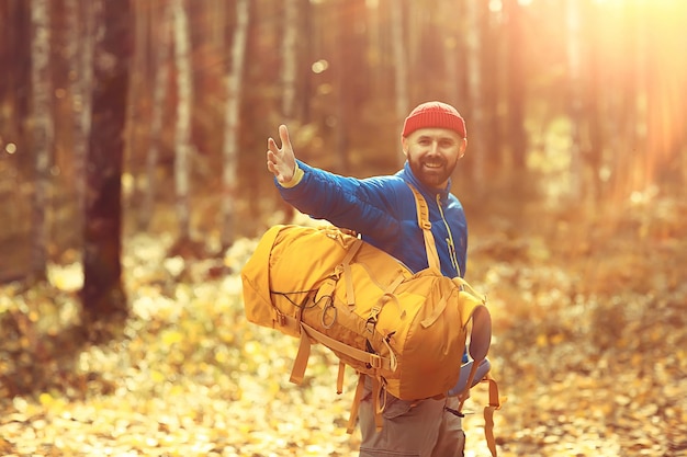 Uomo con zaino una vista dal retro, escursioni nella foresta, paesaggio autunnale, la parte posteriore del turista con uno zaino