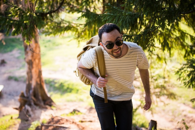 Man with backpack walking through the trees