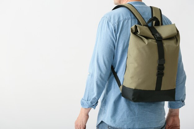 Man with backpack on white surface