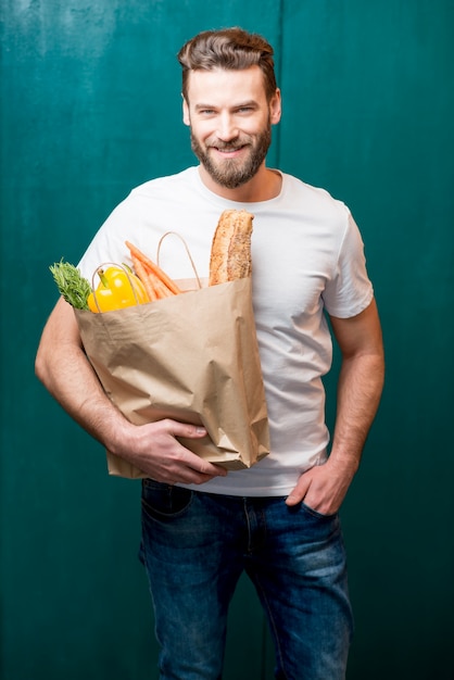 食べ物がいっぱい入ったバッグを持つ男