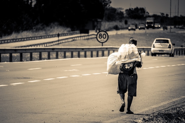 Man with bags on his back walking on the street