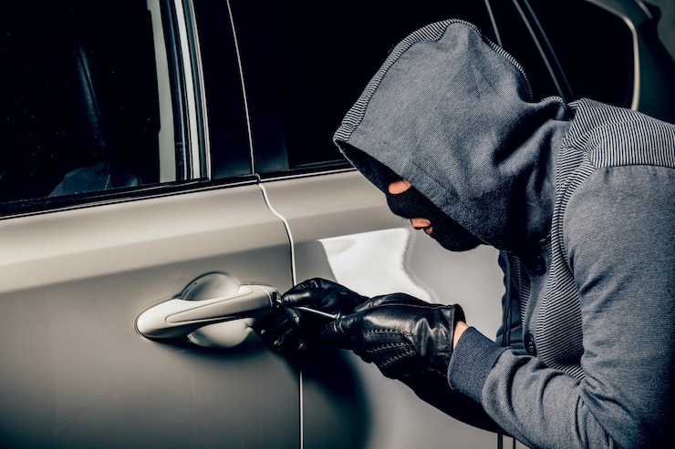 Photo a man with a balaclava on his head tried to break into the car he uses a screwdriver hijacker the concept of car theft