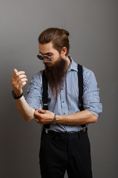 man with a beard in glasses dresses a shirt