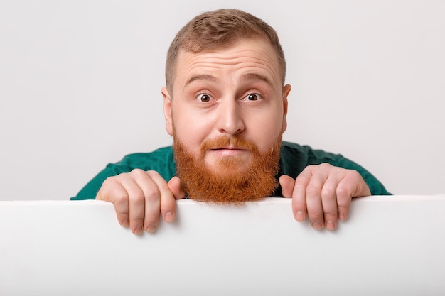 Man with beard holding big white card