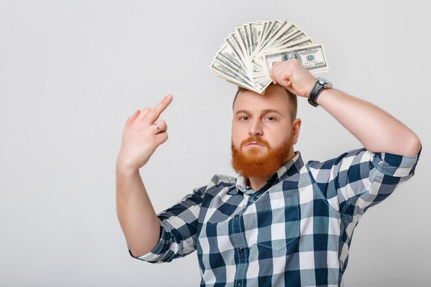 Foto uomo con la barba che tiene un sacco di banconote da cento dollari