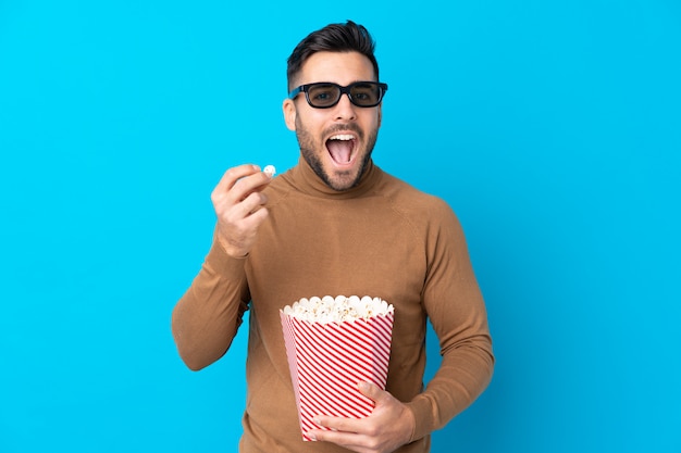 Man with beard holding a popcorns over isolated wall