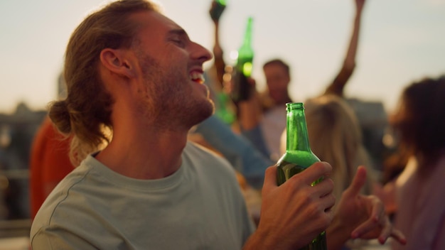 Foto un uomo con la barba sta bevendo una birra.