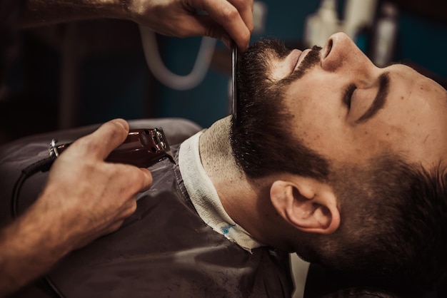 a man with a beard is getting his hair cut