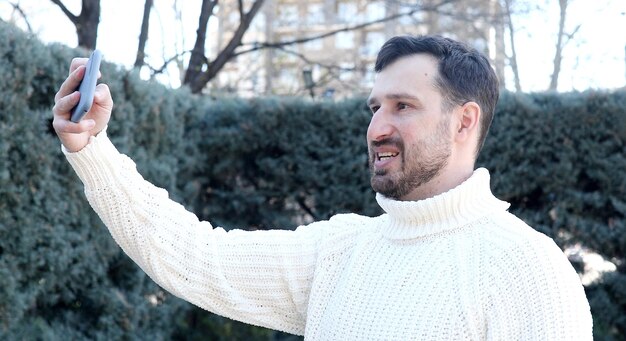 A man with a beard is holding a kite.