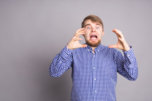 Man with a beard on a light wall bites off invisible food