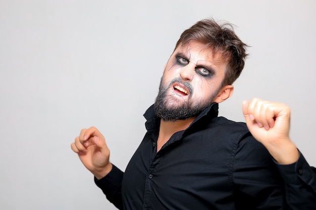 A man with a beard and makeup for Halloween grimaced