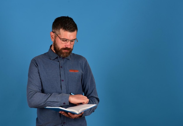 Man with beard reads blue book