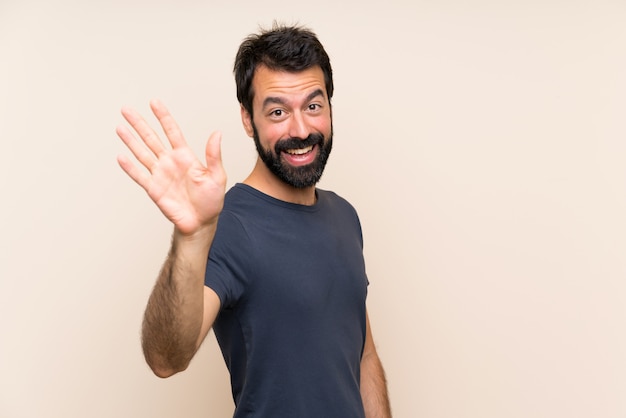 Man with beard saluting with hand with happy expression