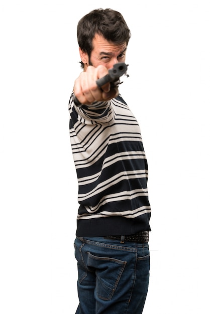 Man with beard shooting with a pistol