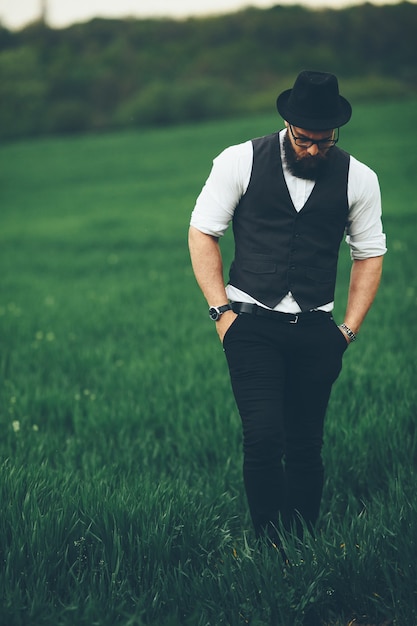 A man with a beard and sunglasses walking on the field