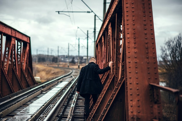 鉄道を歩いてひげを持つ男