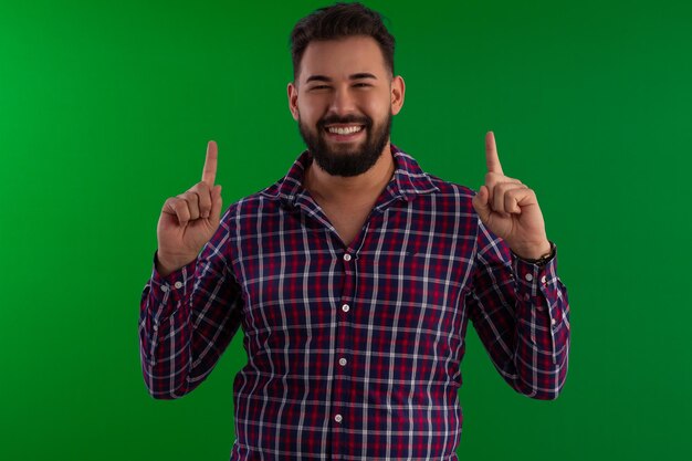 Photo man with a beard wearing a plaid shirt in a studio photo with a green background ideal for cropping