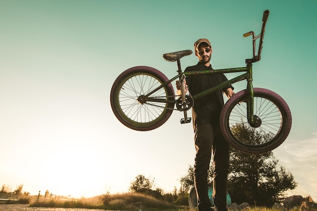 写真 明るい空の前で自転車に乗っている男