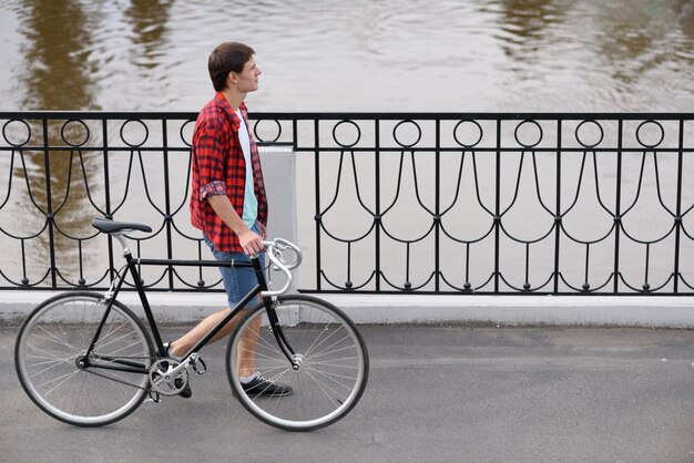 Uomo con la bicicletta che cammina sulla banchina