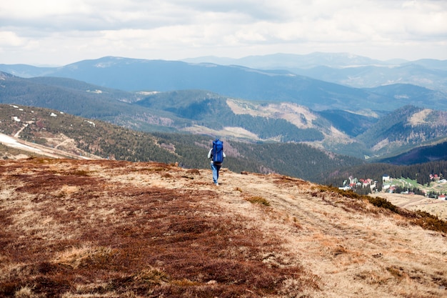 山の中で大きなバックパックを持つ男、大きなバックパックを持つ山の旅行者