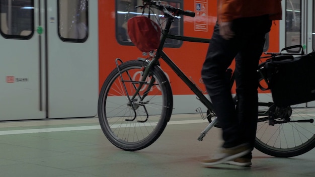 地下鉄の電車を待っている自転車を持つ男