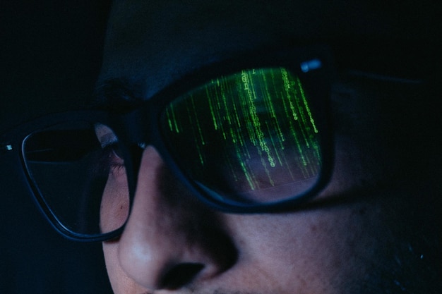 Man with binary code reflected in glasses