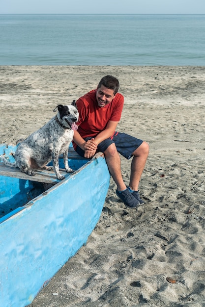 Мужчина с черно-белой собакой на пляже
