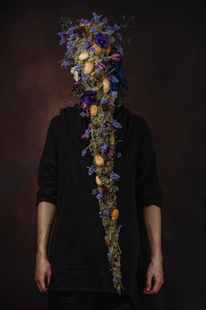 A man with blue flowers on a dark room