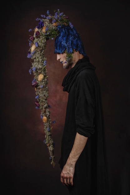 A man with blue flowers on a dark room