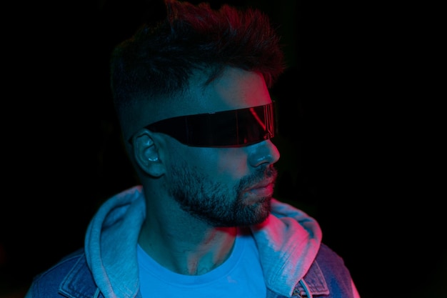 A man with a blue light on his face and a black glasses that say'i'm not a fan '