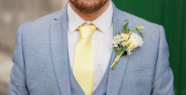 Uomo con un abito blu, una camicia bianca e una cravatta gialla