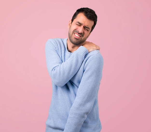 Man with blue sweater suffering from pain in shoulder