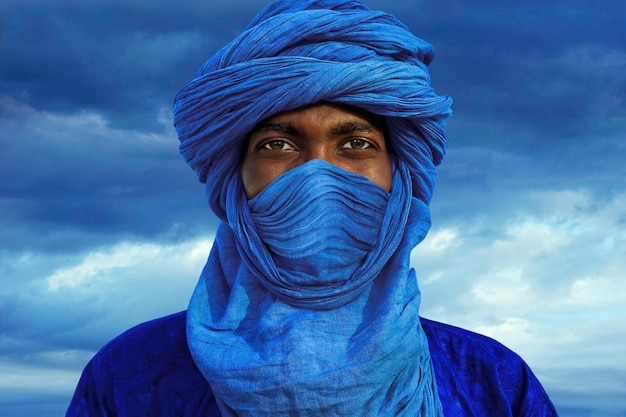 Man with  blue turban posing in camp near timbuktu