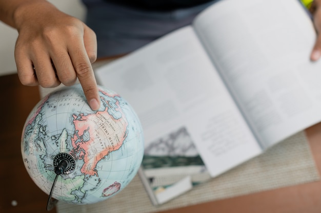 Foto uomo con la pianificazione del libro vacanza in messa a fuoco selettiva, prenotazione di biglietti, viaggi e vacanze concetto