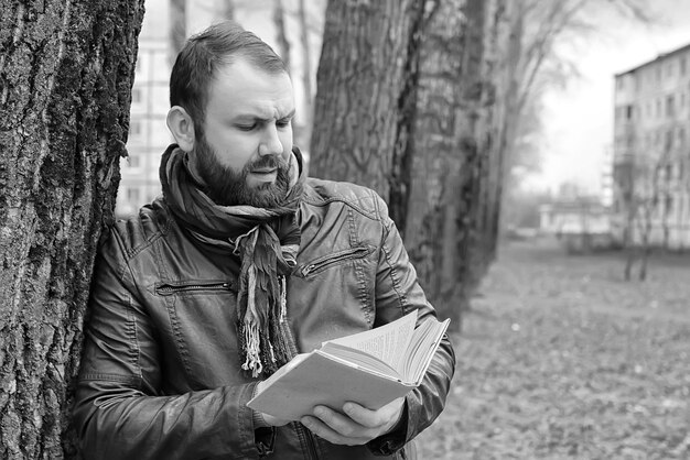 Uomo con libro in inverno all'aperto